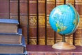 Globe on the background of pile of vintage books