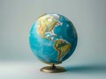 A globe with a blue background and gold stand