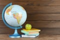 Globe, books and fresh apple on wooden table, space for text. Geography lesson Royalty Free Stock Photo
