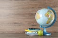 Globe, books, magnifying glass and apple on wooden table, space for text. Geography lesson Royalty Free Stock Photo