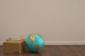Globe and carton on wooden floor 3D illustration. Royalty Free Stock Photo