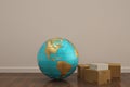 Globe and carton on wooden floor 3D illustration. Royalty Free Stock Photo