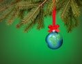 Globe christmas ornament hanging over green. Peace on Earth, eco friendly or winter vacation travel concept Royalty Free Stock Photo