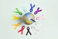 The globe with circle of colorful awareness ribbons on blue background. World cancer day concept, February 4