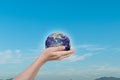 Globe, earth in human hands over blue sky background Royalty Free Stock Photo