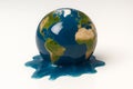 Globe of Earth melting into blue puddle on surface Royalty Free Stock Photo