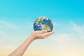 Globe in hands over blue sky background. Save of earth Royalty Free Stock Photo