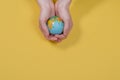 Globe in hands on a yellow background with copy space. The whole world is in your hands. Protect the world from war and disaster Royalty Free Stock Photo