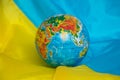 The globe lies on the flags of Ukraine close up Royalty Free Stock Photo