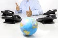 Globe and like hand with office phones on desk, global internati Royalty Free Stock Photo