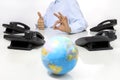 Globe and like hand with office phones on desk, global international support Royalty Free Stock Photo