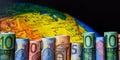 Globe map and many euro bills rolled up, copy space for text Royalty Free Stock Photo