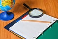 Globe, notebook, pencil and magnifying glass on desk. Royalty Free Stock Photo