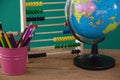 Globe, penholder and abacus on wooden table Royalty Free Stock Photo