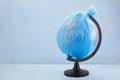 Globe of planet Earth dressed in a garbage plastic bag on blue wooden background