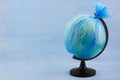 Globe of planet Earth dressed in a garbage plastic bag on blue wooden background