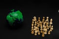 Globe puzzle and white chess pieces isolated on a black background - the power of unity concept Royalty Free Stock Photo