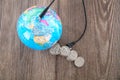 A globe simulates charging a row of dollar coins