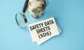 A globe sits on a table with a piece of paper that says Safety Data Sheets (SDS). Royalty Free Stock Photo