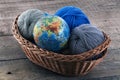 Globe and skeins of yarn in a wicker basket