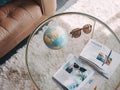 Globe, Sunglasses, and Travel Magazines on Glass Table Royalty Free Stock Photo