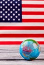 Globe on table with USA flag in the background. Royalty Free Stock Photo