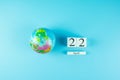Globe and 22th April calendar on blue background. Happy Earth Day and environment concept