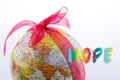 Globe tied with ribbon beside hope wording Royalty Free Stock Photo