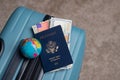 Globe, US passport, American flag and dollars lie on baggage for travel Royalty Free Stock Photo