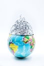Globe wearing a tin foil hat, isolated on white background, concept conspiracy theory