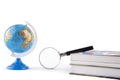 Globe witn magnifying glass on book