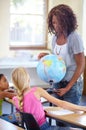 Globe, woman teacher and children in classroom for geography education, world learning and earth knowledge. African Royalty Free Stock Photo