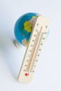 Globe and wooden eco-friendly thermometer on white background. Temperature in Celsius and Fahrenheit. White background. Concept of