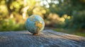 A globe on a wooden surface with a green, blurred background symbolizing environmental conservation Royalty Free Stock Photo