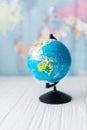 Globe on a wooden white table on the background of a world map. Royalty Free Stock Photo