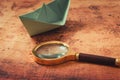 Globetrotter or Journey Explore Concept, Magnifier Glass and Paper Boat Layout on World Map Background, Still-Life Creative Idea.,