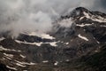 gloomy atmospheric rocks, dark mountains covered with clouds and puffs of fog. Mountain peak of snow-capped mountains, beautiful Royalty Free Stock Photo