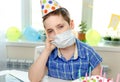 Gloomy child sitting in front of a piece of cake. Birthday party alone Royalty Free Stock Photo