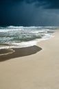 Gloomy dark cloudy sky, turbulent sea waves. Empty overcast beach just before the wild rainfall