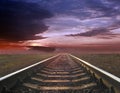 Gloomy landscape with rails going away into the far sunset Royalty Free Stock Photo