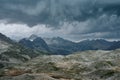 Gloomy mountain landscape with thunder cloudy sky, rocky ranges and peaks with glaciers and snow fields Royalty Free Stock Photo