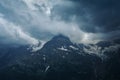 Gloomy mountain top landscape with thunder cloudy sky, rocky ranges and peaks with glaciers and snow fields Royalty Free Stock Photo