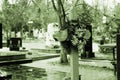 Gloomy photo of a wooden cross with artificial flowers in a cemetery