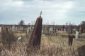 Gloomy rickety abandoned obelisk gravestone with a cross in a cemetery on a cloudy autumn day. Forgotten old grave Royalty Free Stock Photo