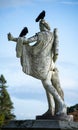 Gloomy statue of Eros with 2 sinister crows on the head. 2 black ravens on Eros statue convey bad feeling and rejection for love Royalty Free Stock Photo