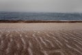 Gloomy tricolor sandy snowy shore of Lake Baikal in late autumn