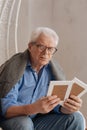 Gloomy unhappy man having old photos in his hands