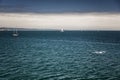 Gloomy weather on the sea. Dark blue water with yachts sailing on it. Royalty Free Stock Photo