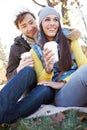 Glorious Autumn Morning. An affectionate young couple sitting together while enjoying some coffee on an autumn day.