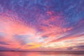 Glorious beautiful colorful sunset with colors stringing out from horizon over ocean with yellow and pink bursting into dappled